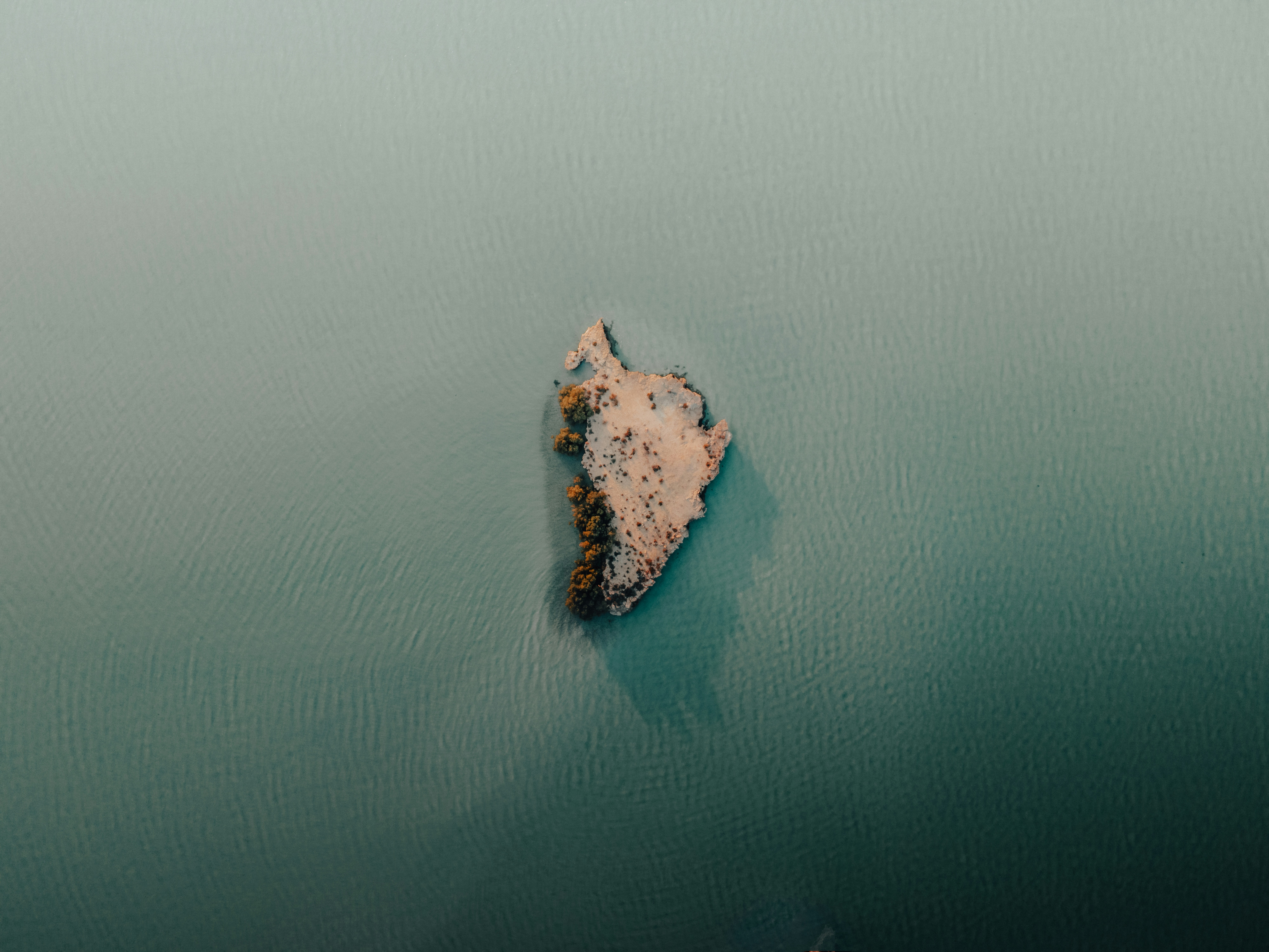 brown rock formation on body of water during daytime