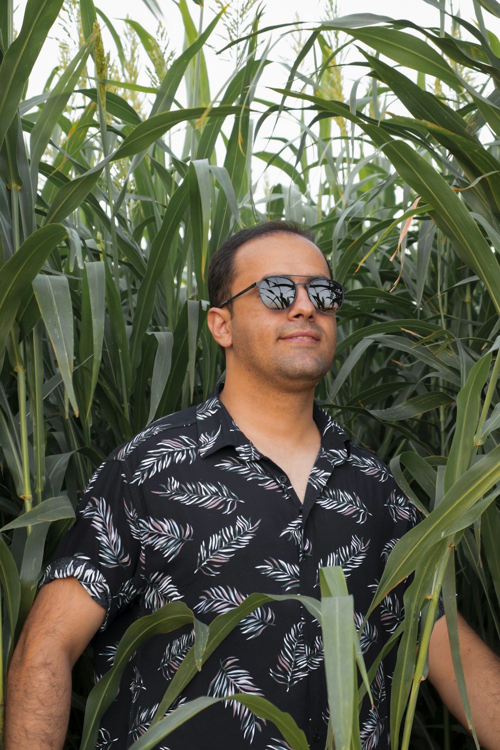 man in black and white floral button up shirt wearing black sunglasses