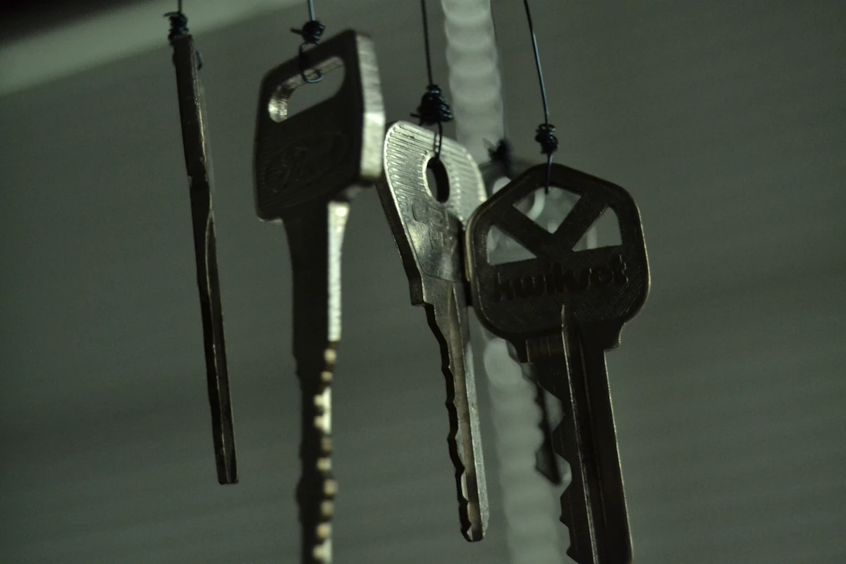 Black and silver keys on white wooden table