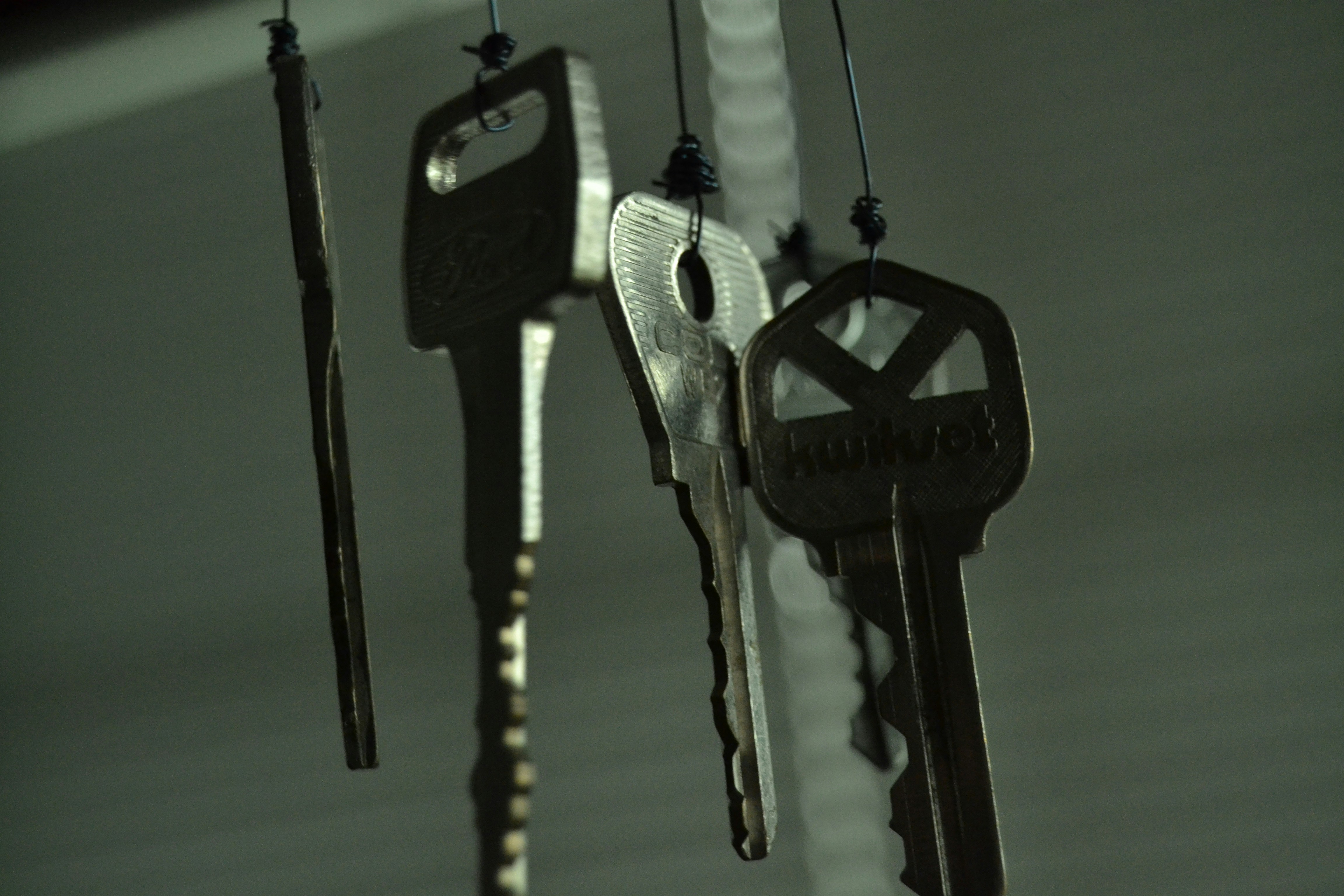 five silver keys hanging on wires