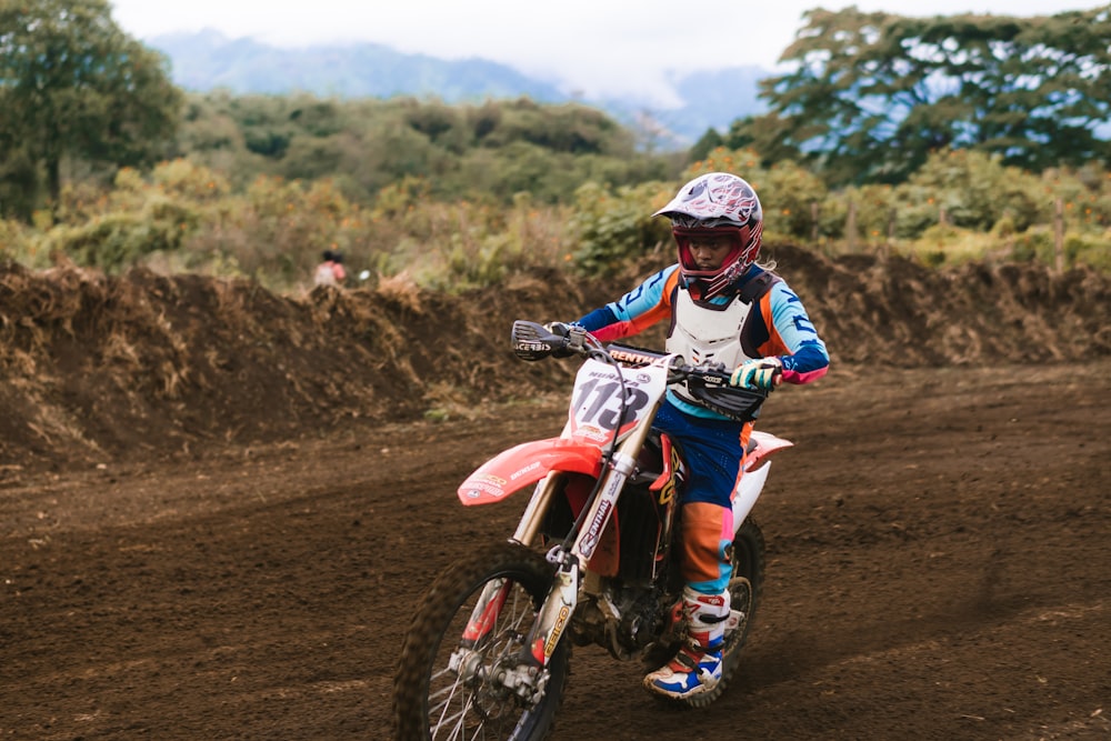 Foto Hombre en traje de motocross azul y blanco montando motocross cross –  Imagen Motocross gratis en Unsplash