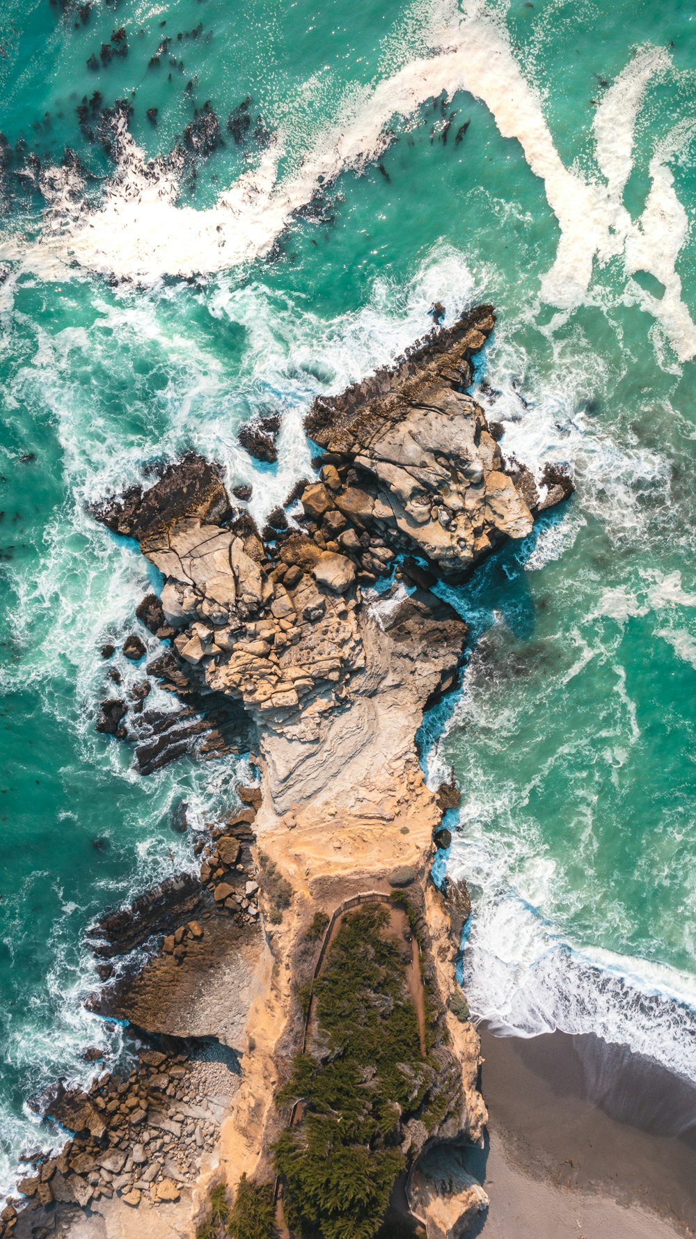 brown rock formation on body of water during daytime