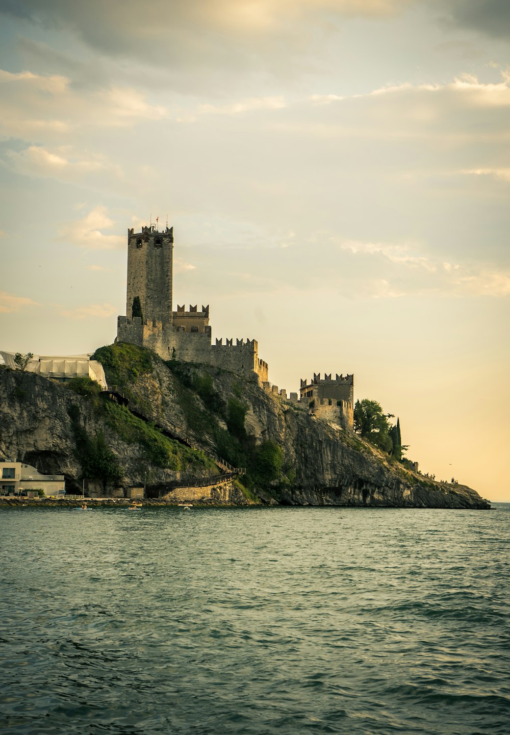 Castillo de hormigón marrón en formación rocosa verde y marrón junto al mar durante el día