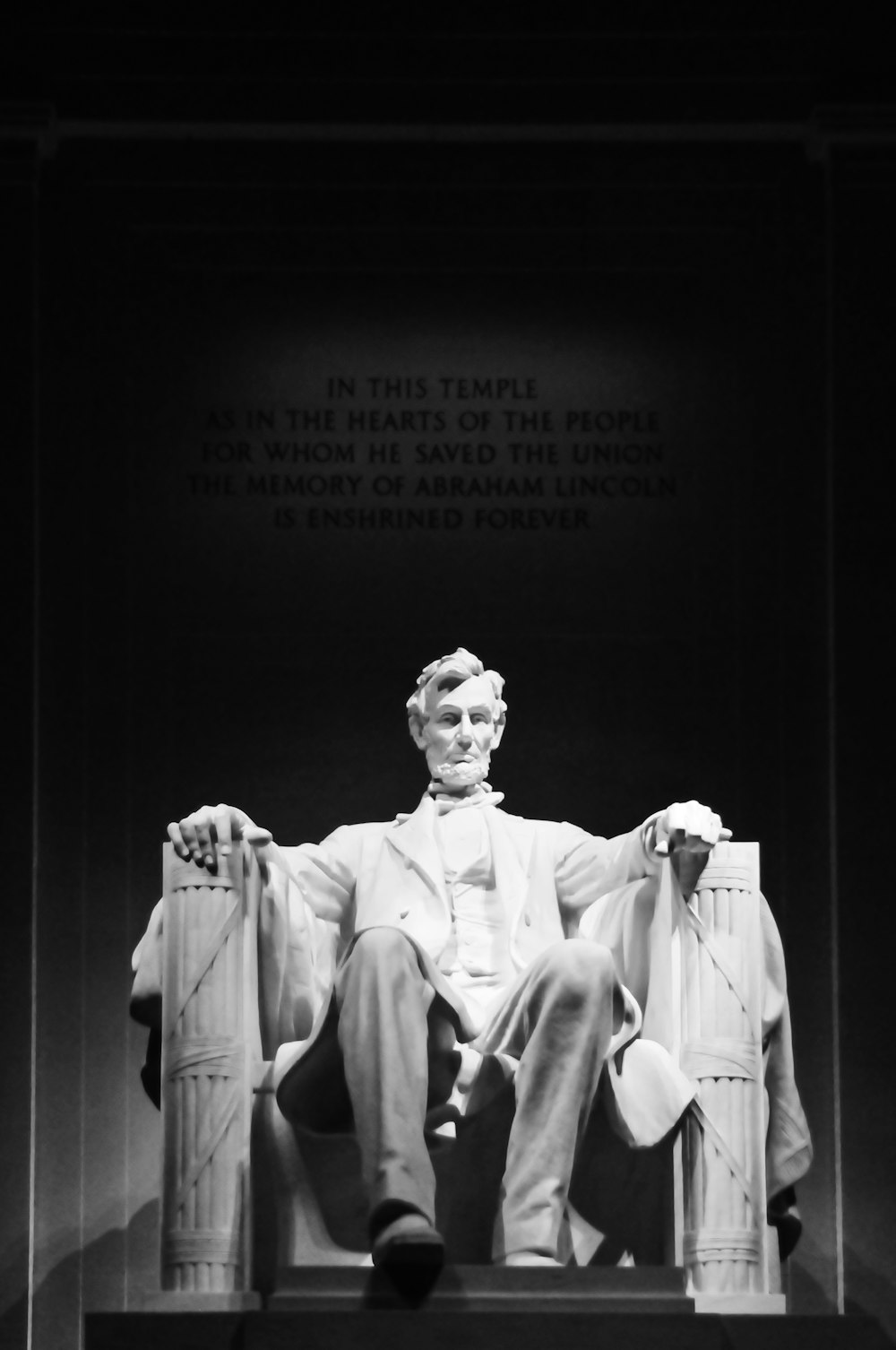 man in white suit jacket sitting on chair statue