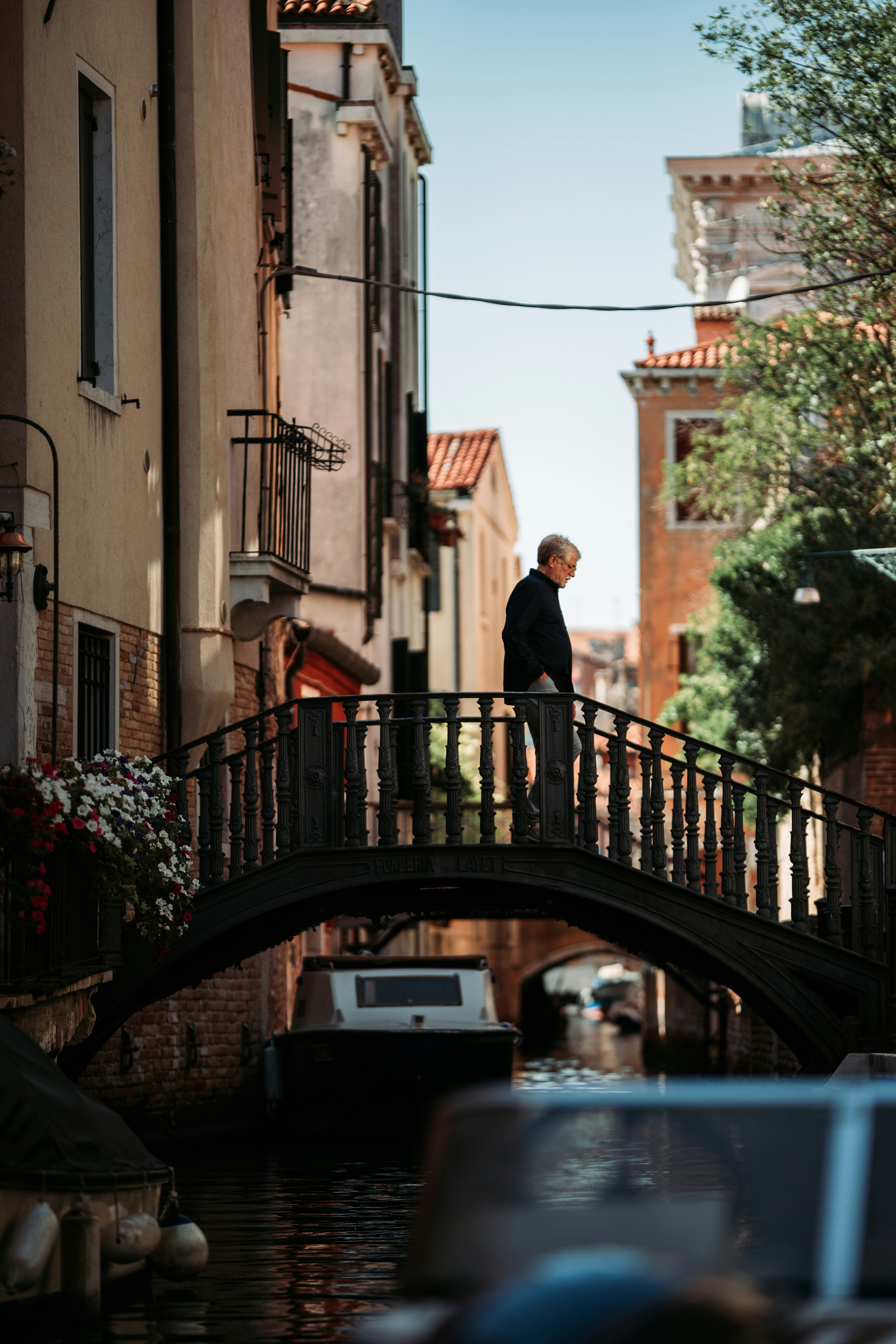 man in black suit standing on black metal bridge during daytime