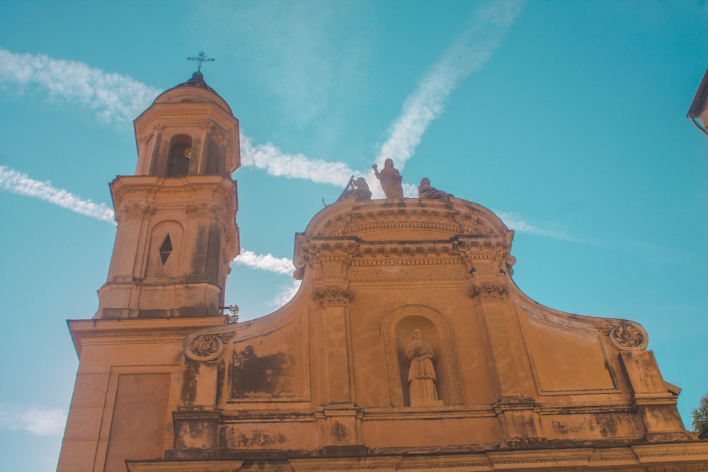 brown concrete church under blue sky and white clouds during daytime