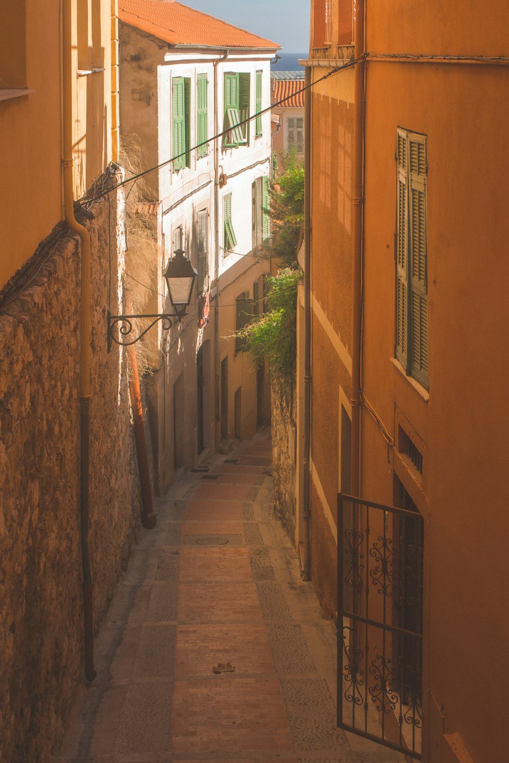 brown brick pathway between brown concrete buildings during daytime