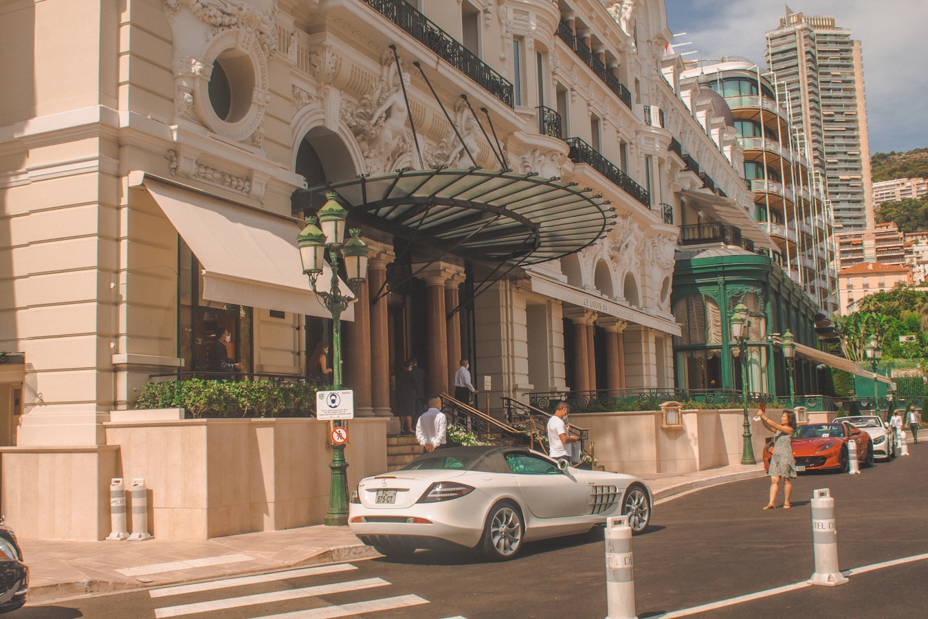 white coupe parked beside brown concrete building during daytime