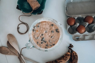 A warm kitchen scene showing hands mixing chocolate batter in a bowl with baking tools around.