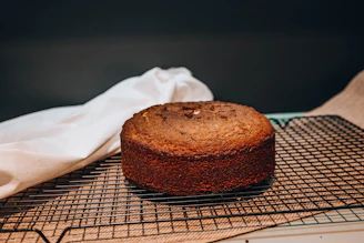 Warm close-up photo of a freshly baked homemade cake with delicate caramel glaze on a rustic wooden table.