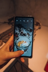 Hands holding a smartphone showing the customized lens prescription upload screen.