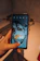 A close-up shot of the black élánmag bottle with a smartphone securely attached by the magnetic lid.