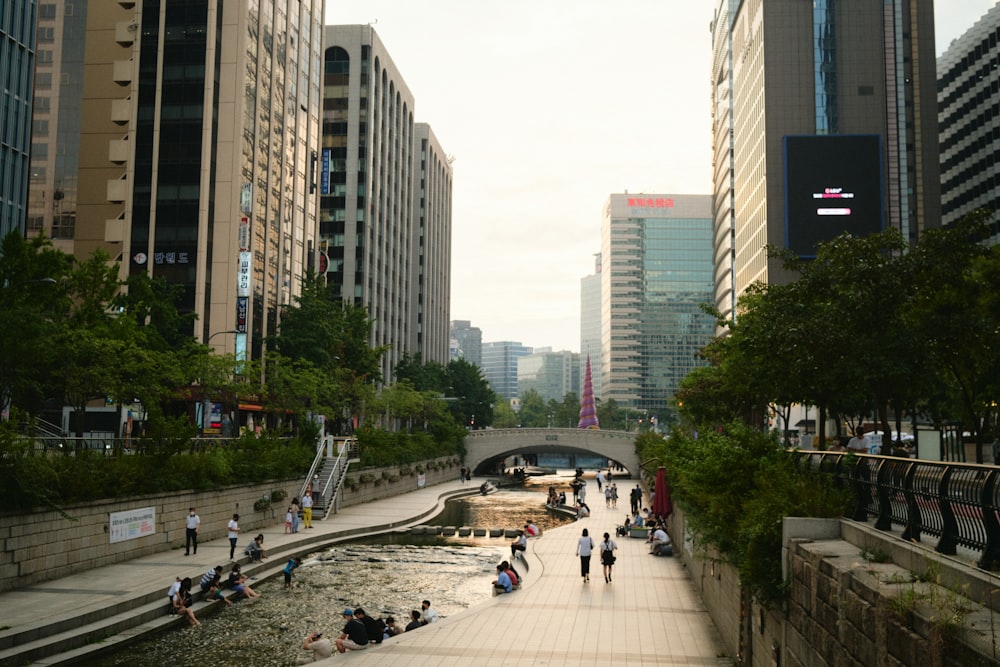 people walking on sidewalk near high rise buildings during daytime