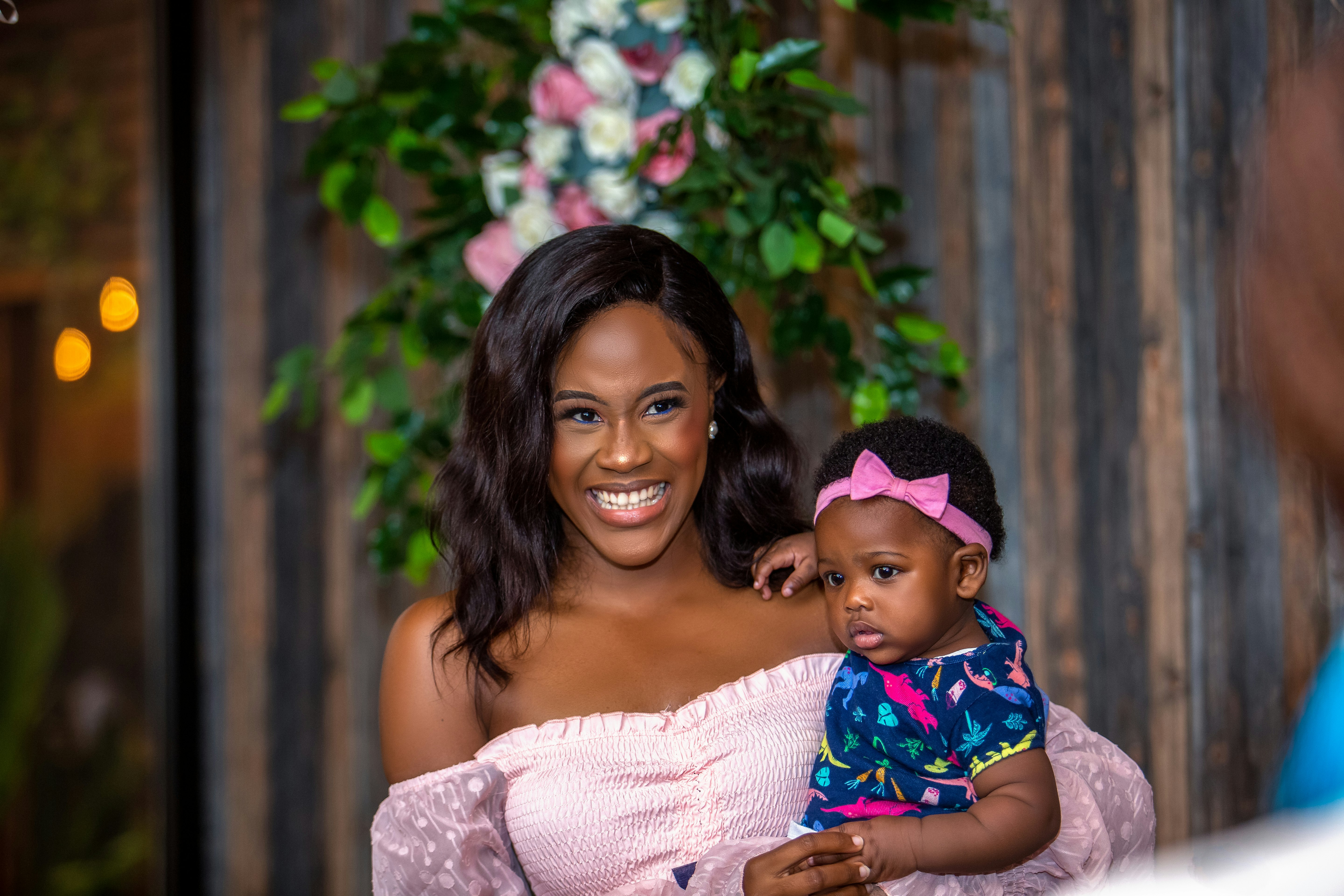 woman in white lace dress carrying baby in blue and white polka dot dress