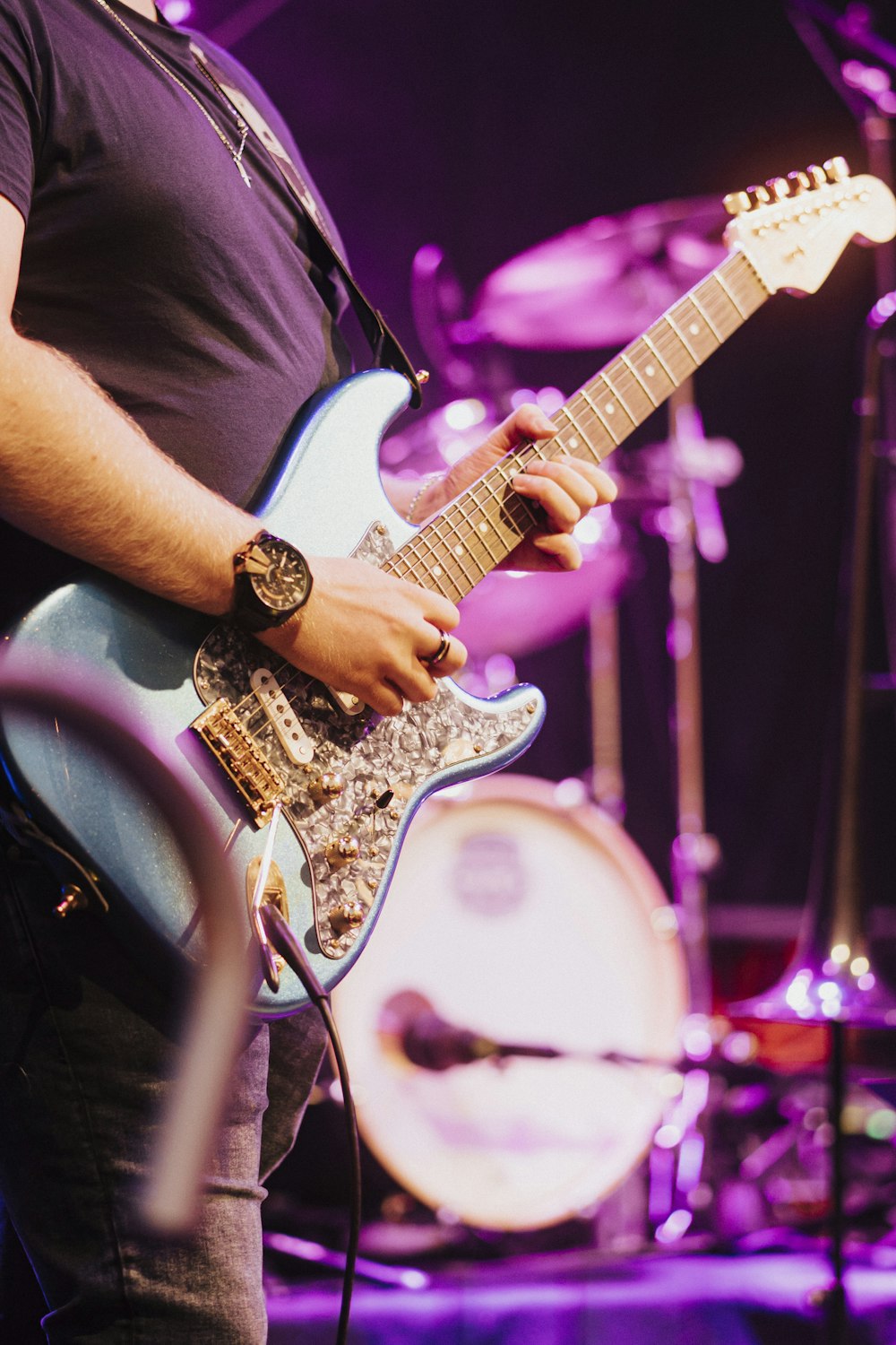 man in black t-shirt playing electric guitar