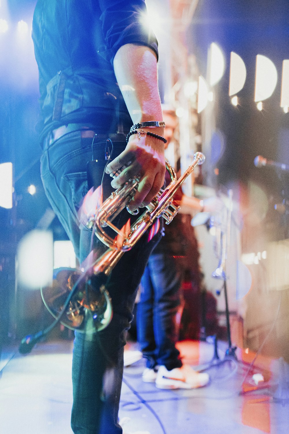 man in blue t-shirt playing brass trumpet