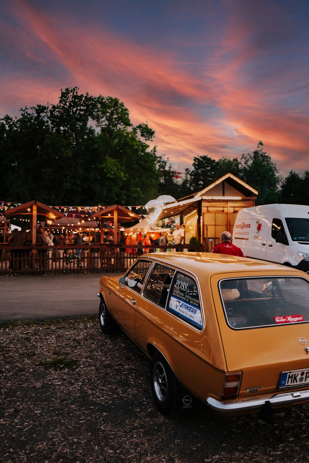 white and brown station wagon parked near brown wooden house during daytime