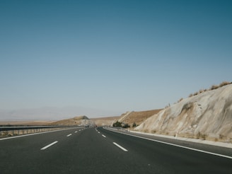 black asphalt road near brown mountain during daytime
