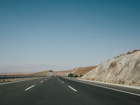black asphalt road near brown mountain during daytime
