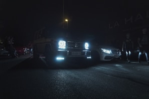 A warm, inviting evening scene with luxury cars under soft orange lighting.
