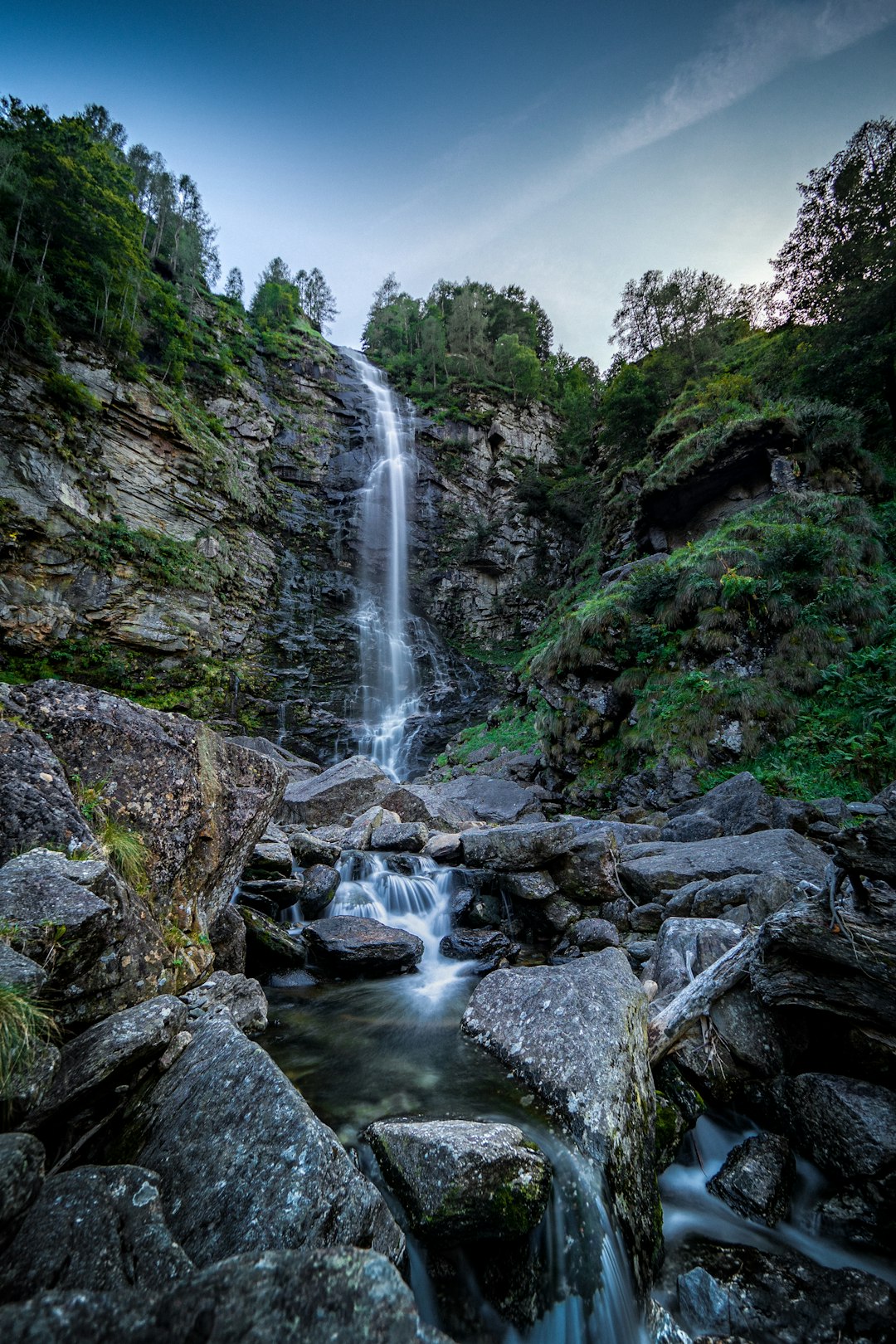 waterfalls in the middle of green trees