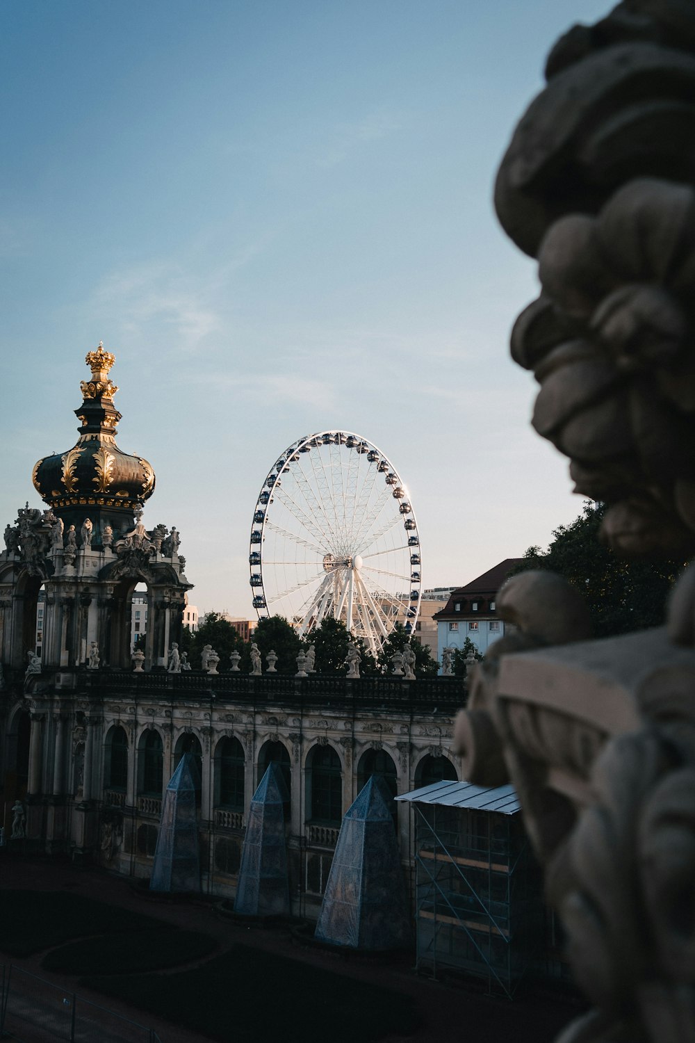 people walking on park with ferris wheel in the background during daytime