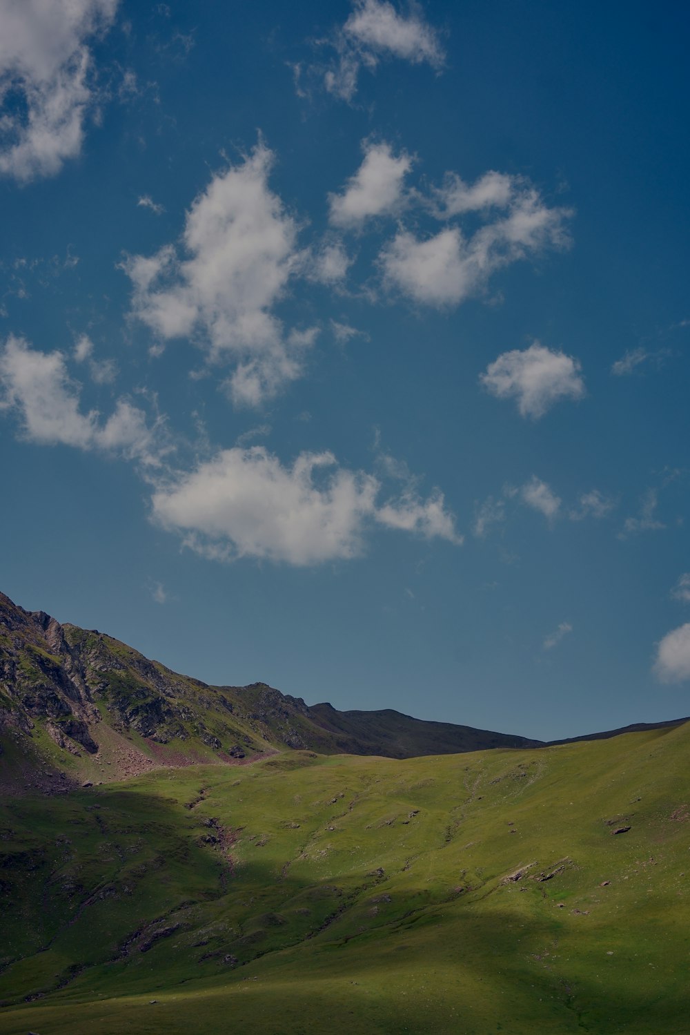 green and brown mountain under blue sky and white clouds during daytime