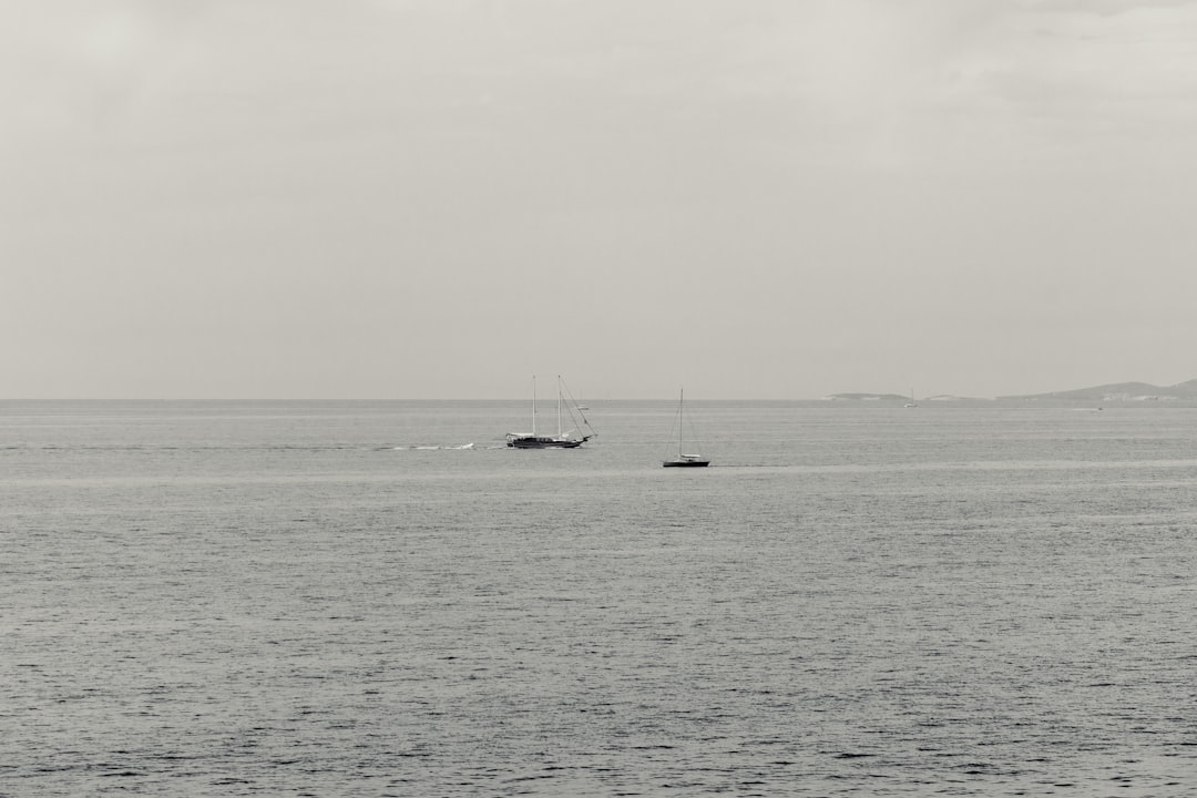 white boat on sea under white sky during daytime