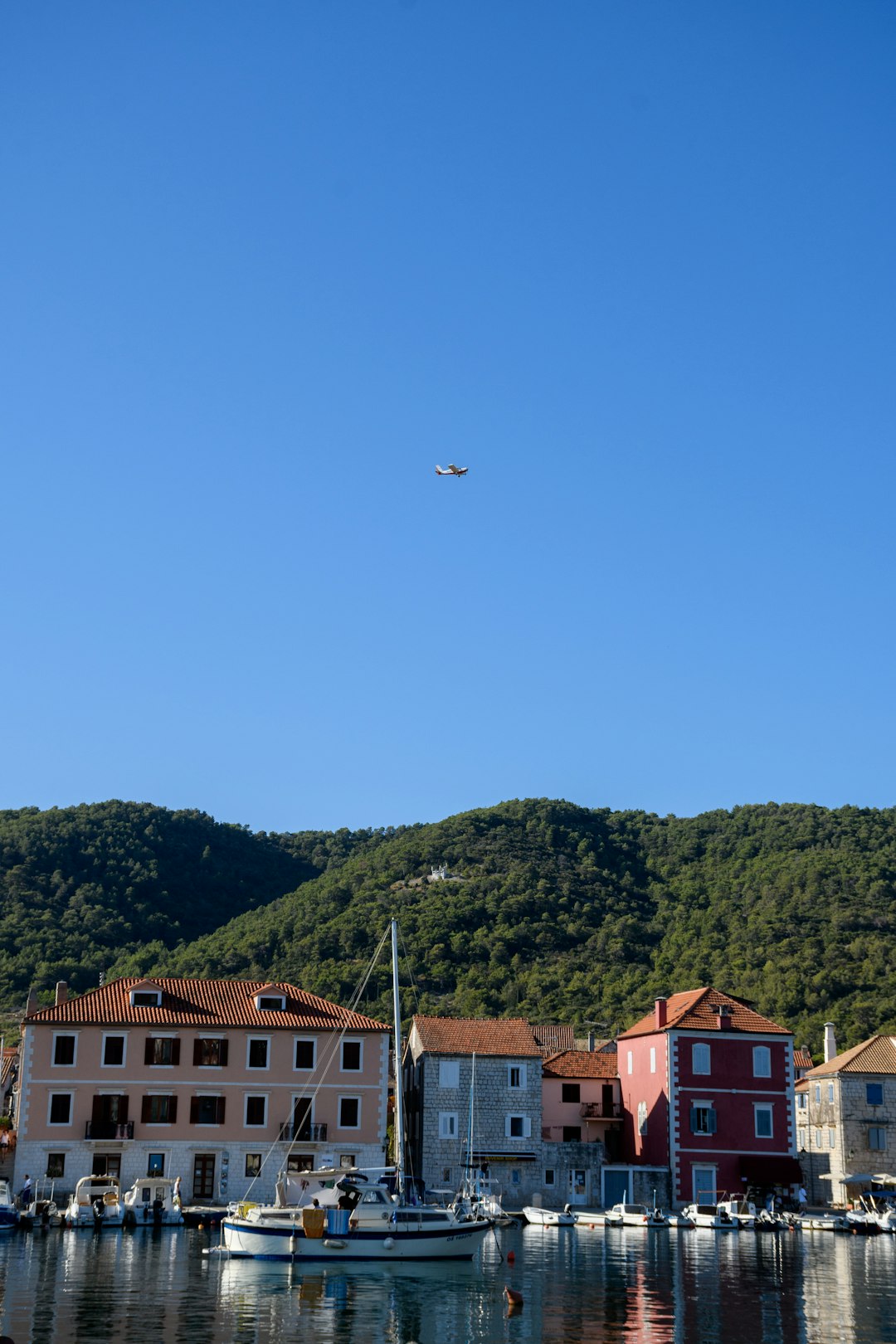 red and white concrete building near green mountain under blue sky during daytime