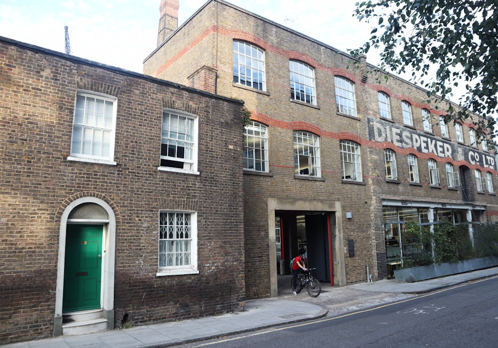 brown brick building with green glass window