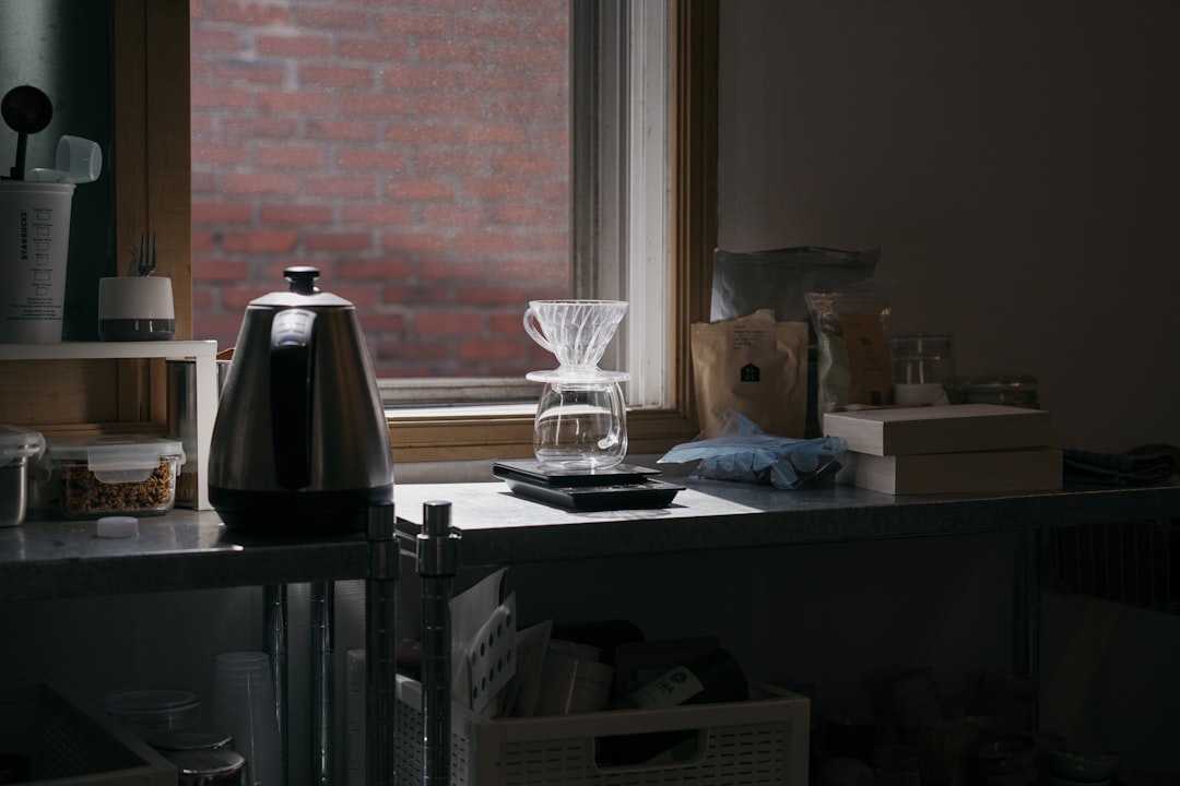 silver and black thermal carafe on table