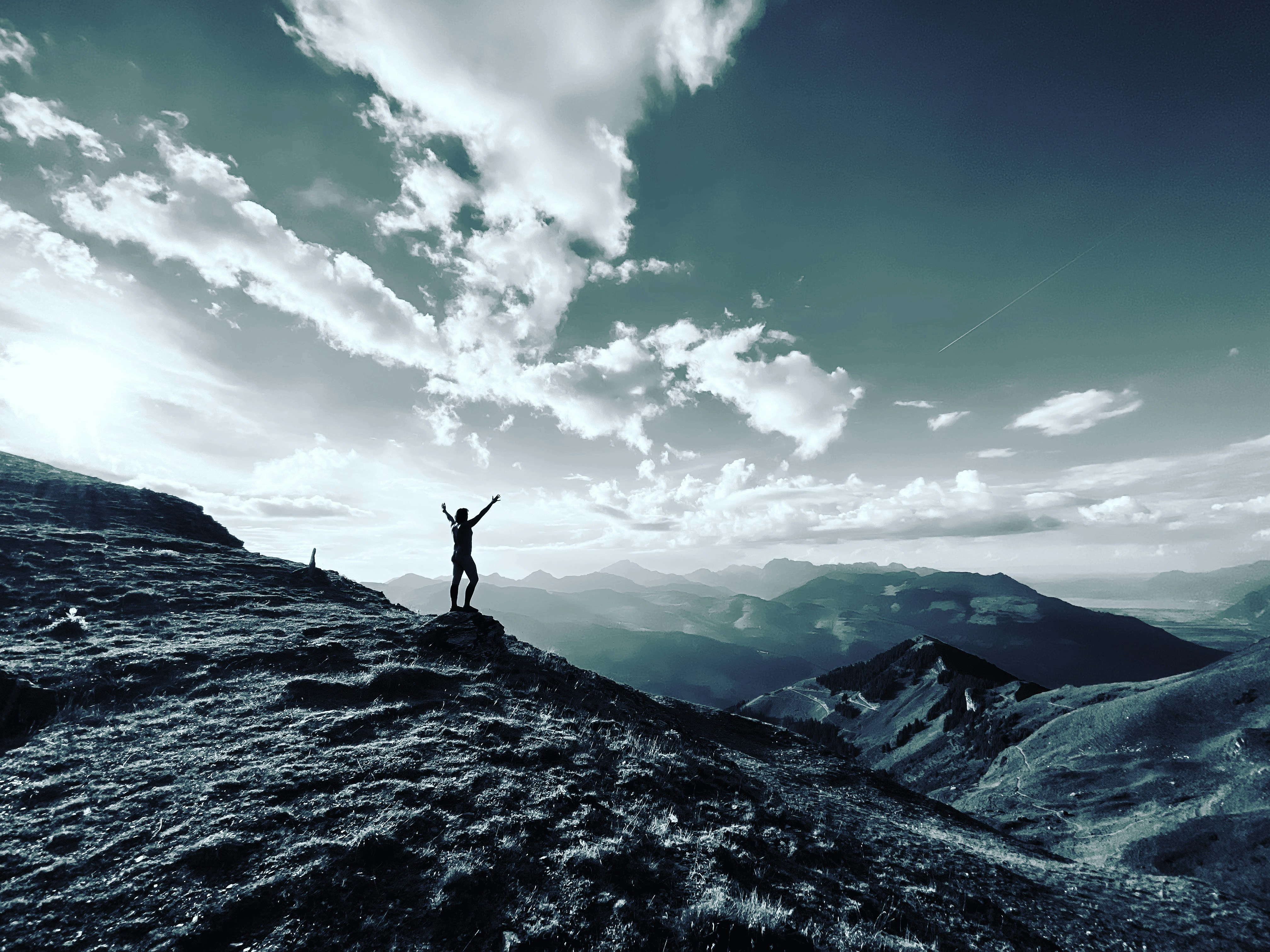 낮에 푸른 하늘과 흰 구름 아래 바위 위에 서 있는 사람