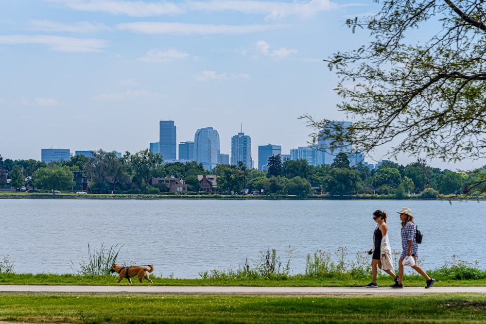 woman in white dress walking on road near body of water during daytime