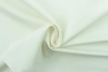 Close-up of soft organic cotton fibers arranged in a delicate spiral pattern.