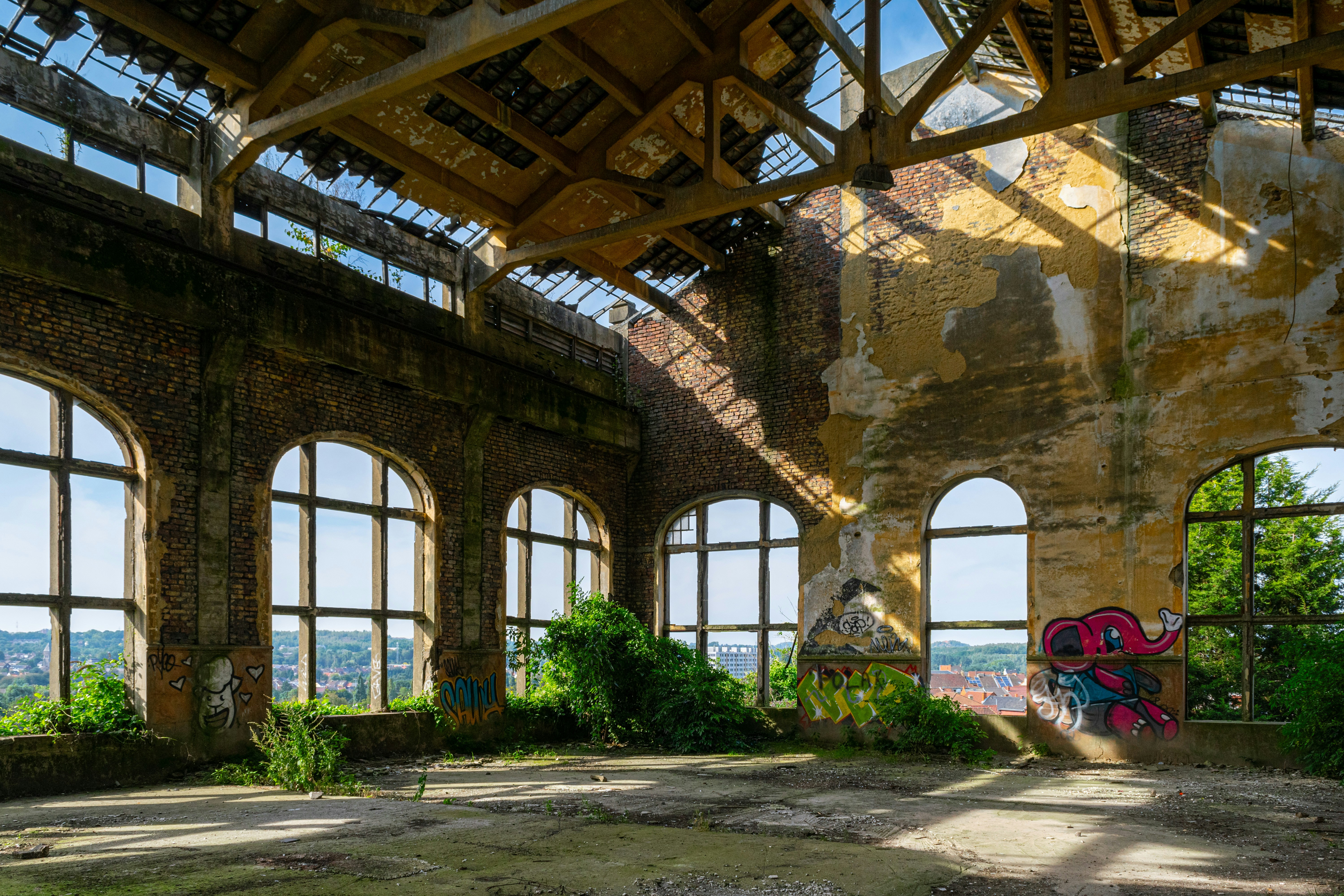 日中の緑の木々の近くの茶色のコンクリートアーチ