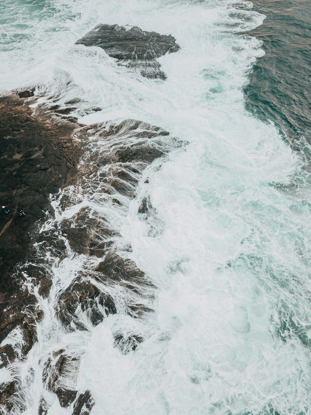 ocean waves crashing on rocky shore during daytime