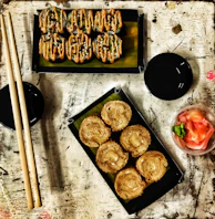 A rustic wooden table set with chopsticks, soy sauce, and a variety of sushi rolls.