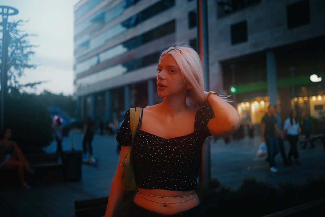 woman in black tank top and orange shorts standing near building during daytime