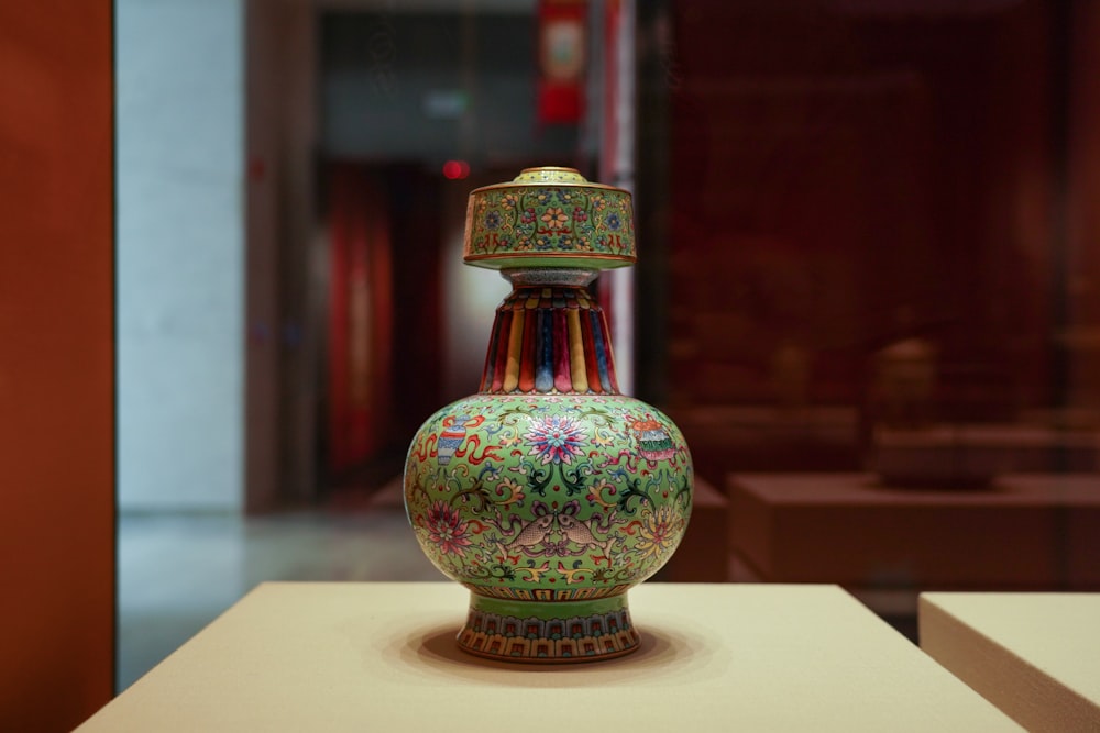 red green and yellow glass vase on white table