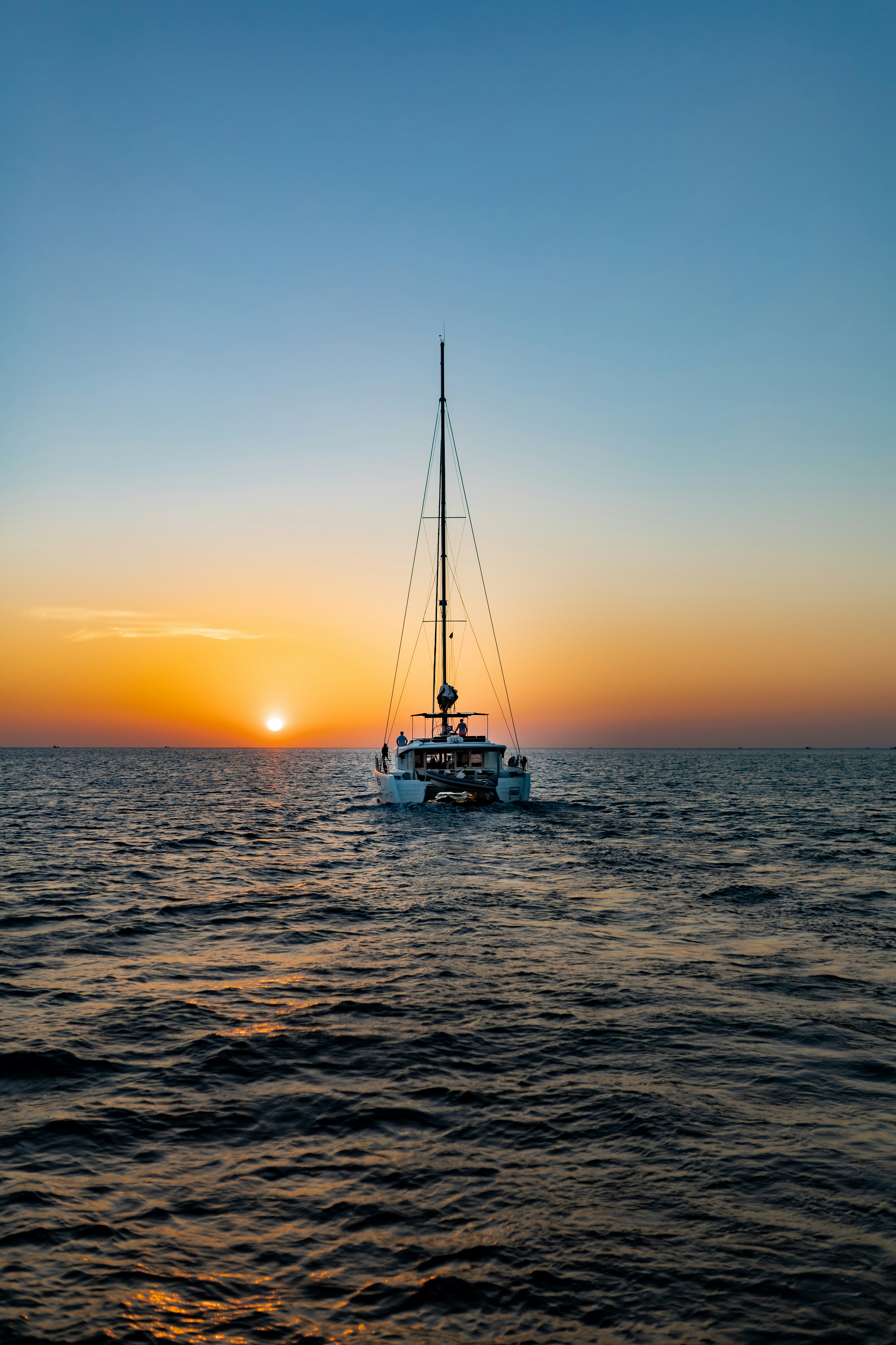 white and blue boat on sea during sunset