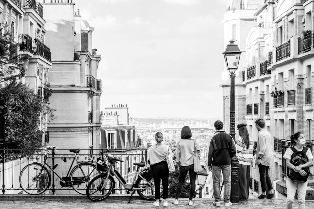 grayscale photo of people standing on the beach