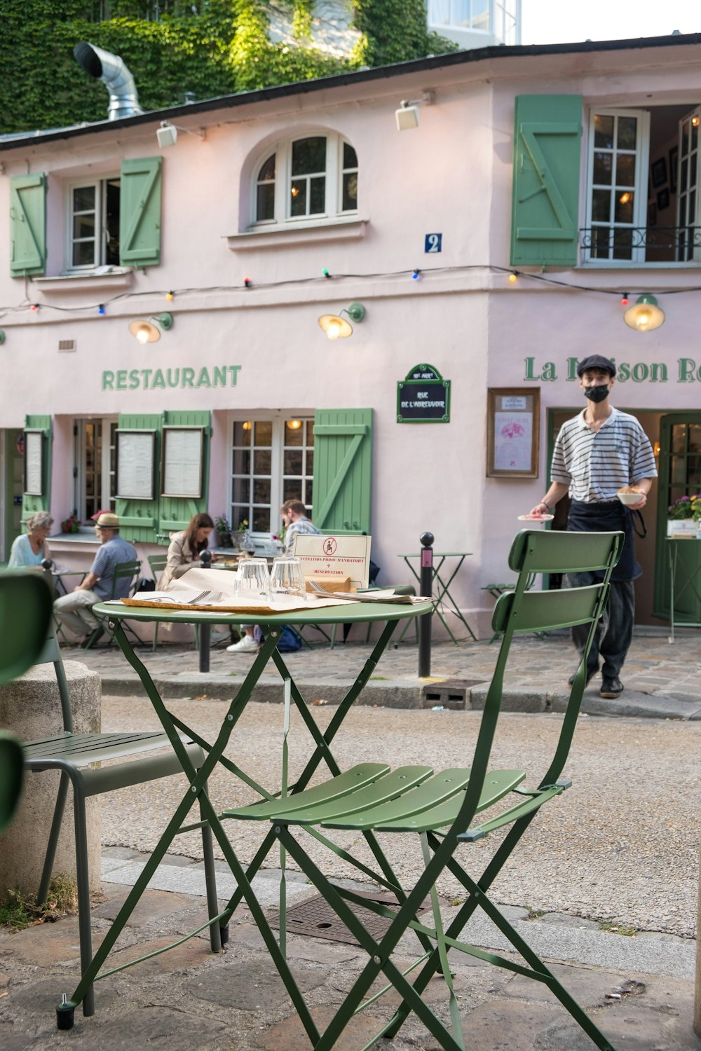 man and woman sitting on green chair near table during daytime