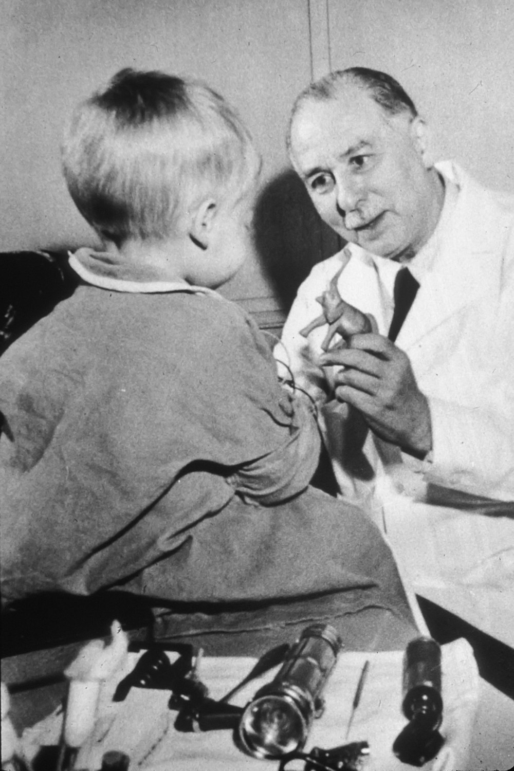 boy in white dress shirt holding a boy in black and white suit