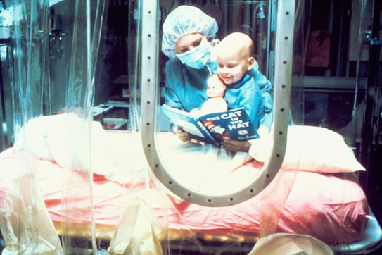 A caregiver wearing surgical attire reads 