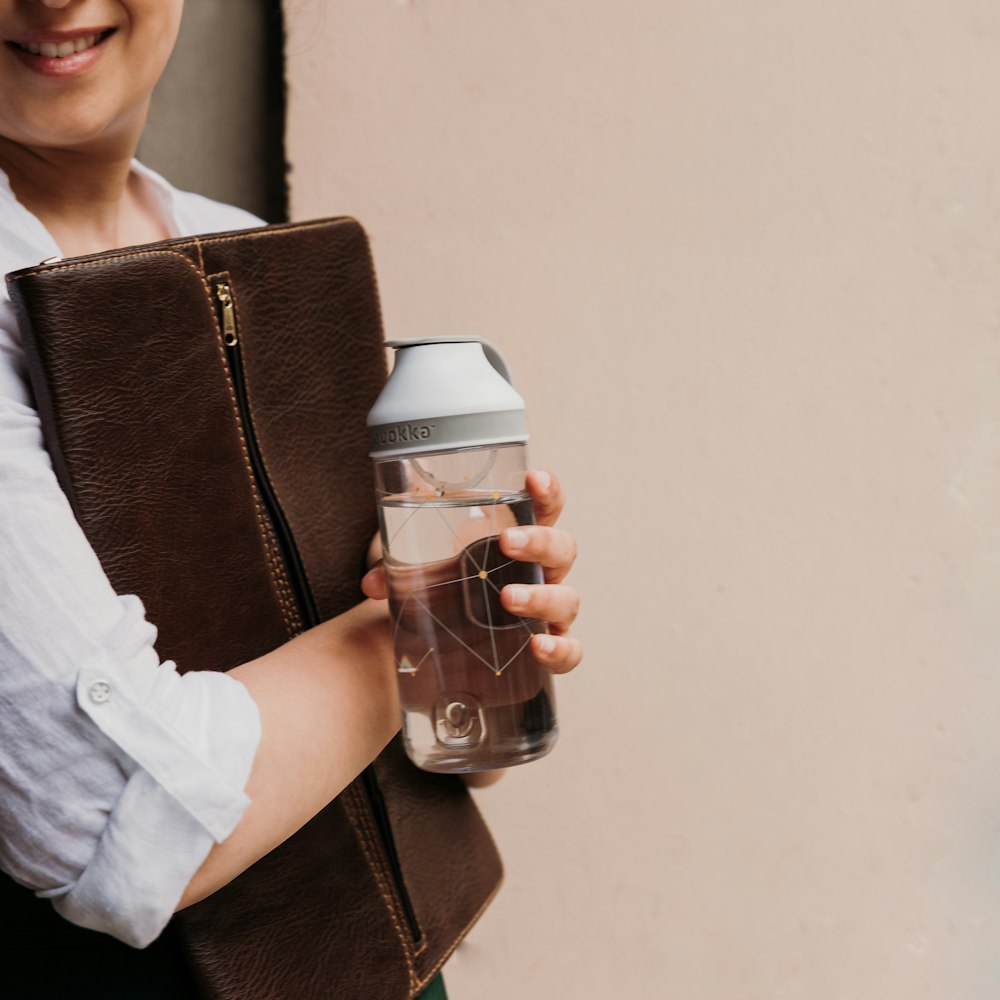 woman in white shirt holding white and black plastic cup