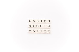 Tile letters arranged to form the words 'BABIES RIGHTS MATTER' on a white background.