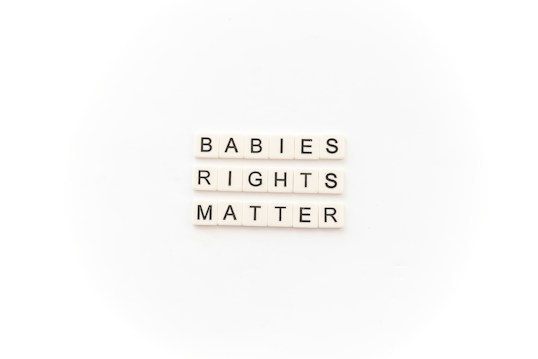 Tile letters arranged to form the words 'BABIES RIGHTS MATTER' on a white background.