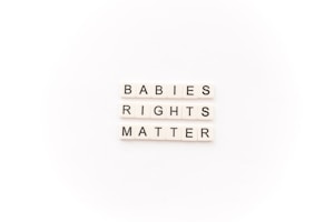 Tile letters arranged to form the words 'BABIES RIGHTS MATTER' on a white background.