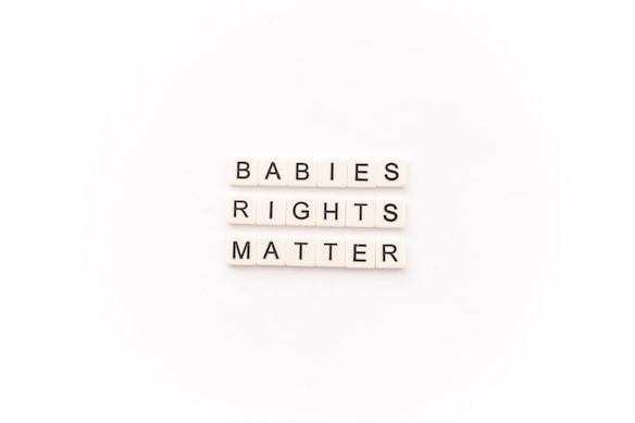 Tile letters arranged to form the words 'BABIES RIGHTS MATTER' on a white background.
