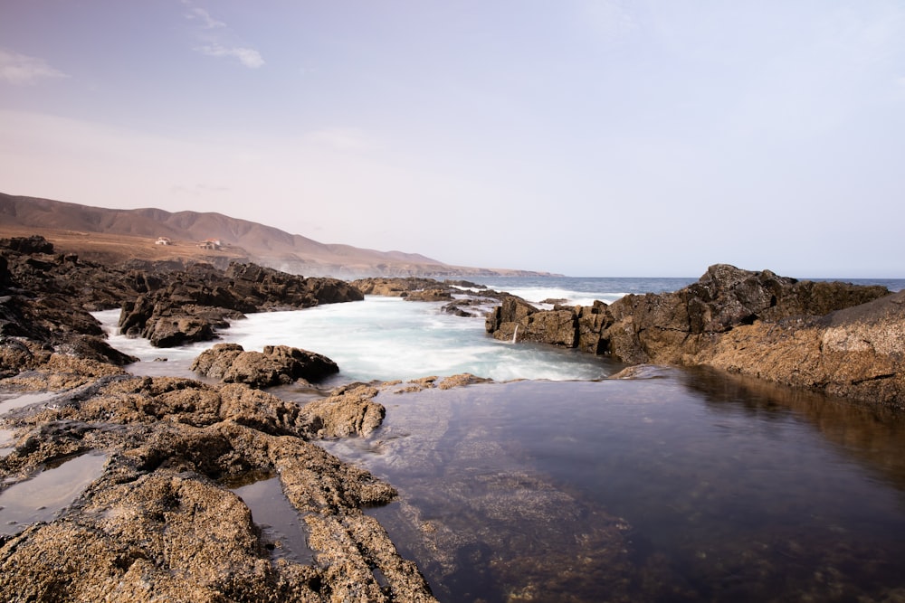 brown rocky shore under blue sky during daytime